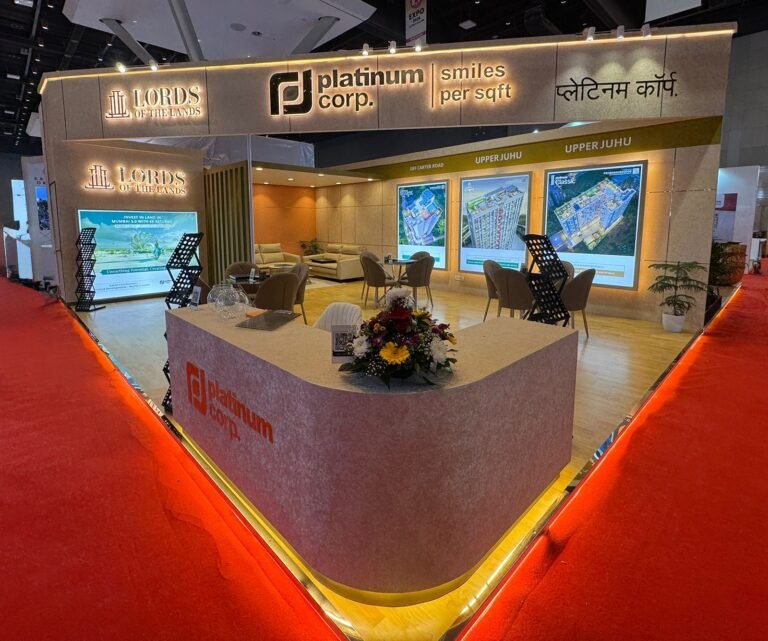 Platinum Corp. exhibition stall featuring premium illuminated branding, luxury property displays, warm ambient lighting, and an open meeting space showcasing creative exhibition stall decoration ideas.