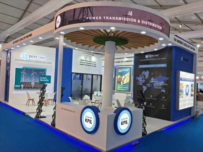 KPIL exhibition stall featuring a circular hanging display, LED branding, interactive digital screens, and modern open seating, showcasing creative exhibition stall decoration ideas at a trade show.