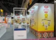 Trade show booth design by a top exhibition stall designer in Mumbai featuring Gujjuben branding, bold product graphics, interactive displays, and an open exhibition layout at Indus Food Expo.