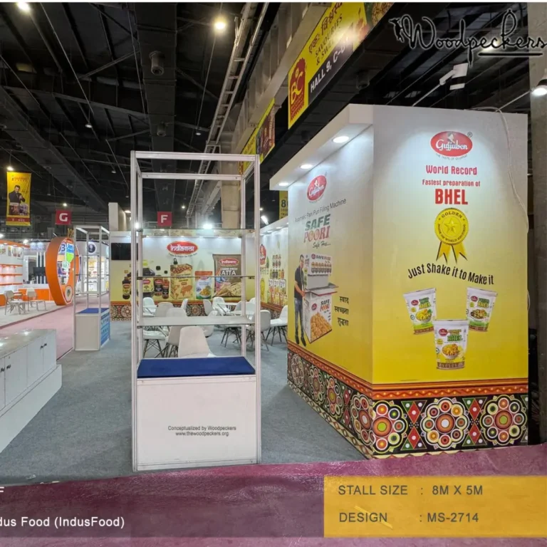 Trade show booth design by a top exhibition stall designer in Mumbai featuring Gujjuben branding, bold product graphics, interactive displays, and an open exhibition layout at Indus Food Expo.
