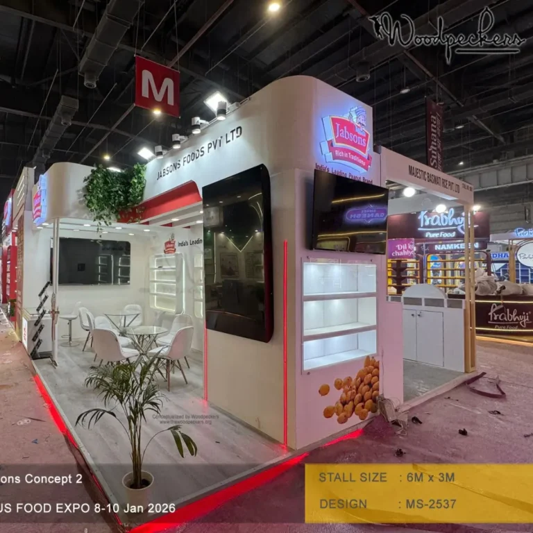 3D exhibition stall design for Jabsons Foods featuring illuminated branding, LED display screens, modern product display shelves, and an open meeting area by a premier exhibition stall design company.